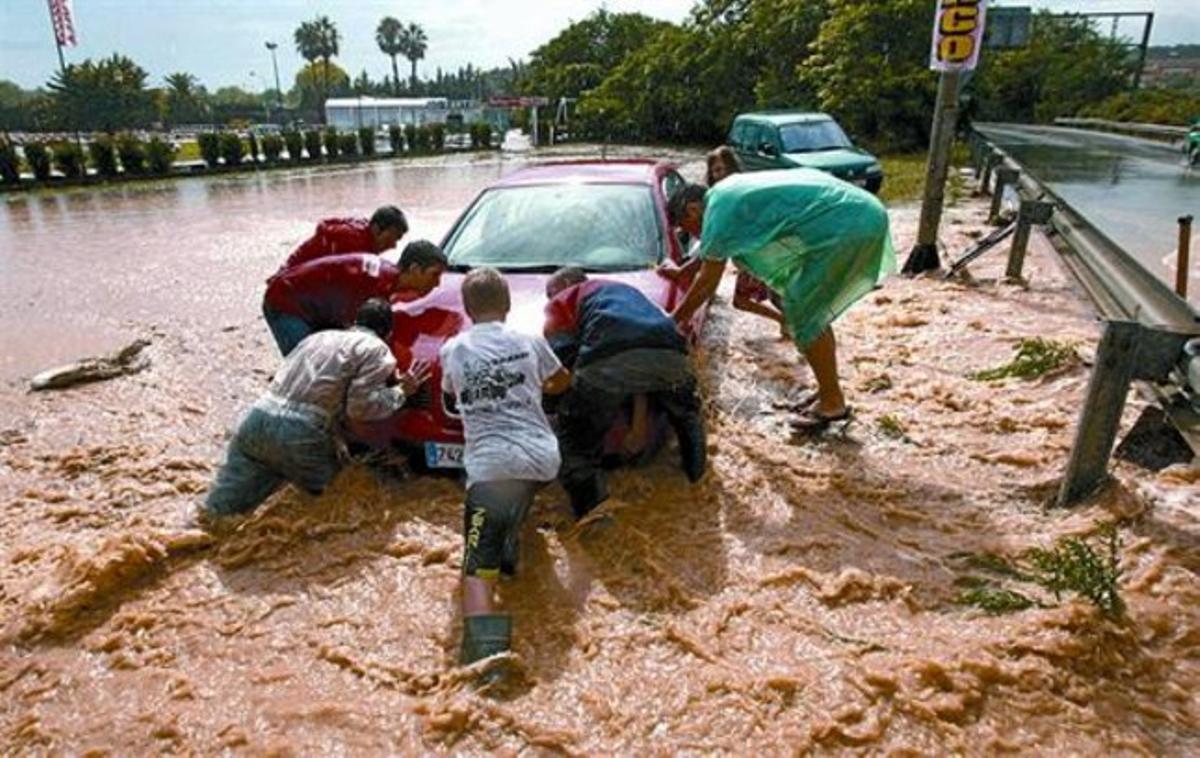 Diverses persones intenten rescatar un cotxe atrapat en una riera inundada d’Altafulla, ahir a la tarda. Diverses persones intenten rescatar un cotxe atrapat en una riera inundada d’Altafulla, ahir a la tarda.