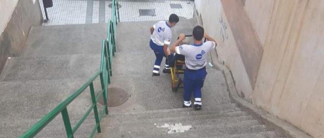Dos sanitarios transportan a un enfermo por una de las escaleras de La Paterna