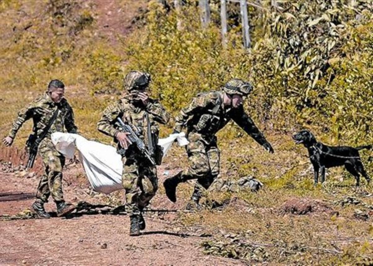 Soldats colombians carreguen el cos d’un dels seus companys mort en el xoc amb les FARC.