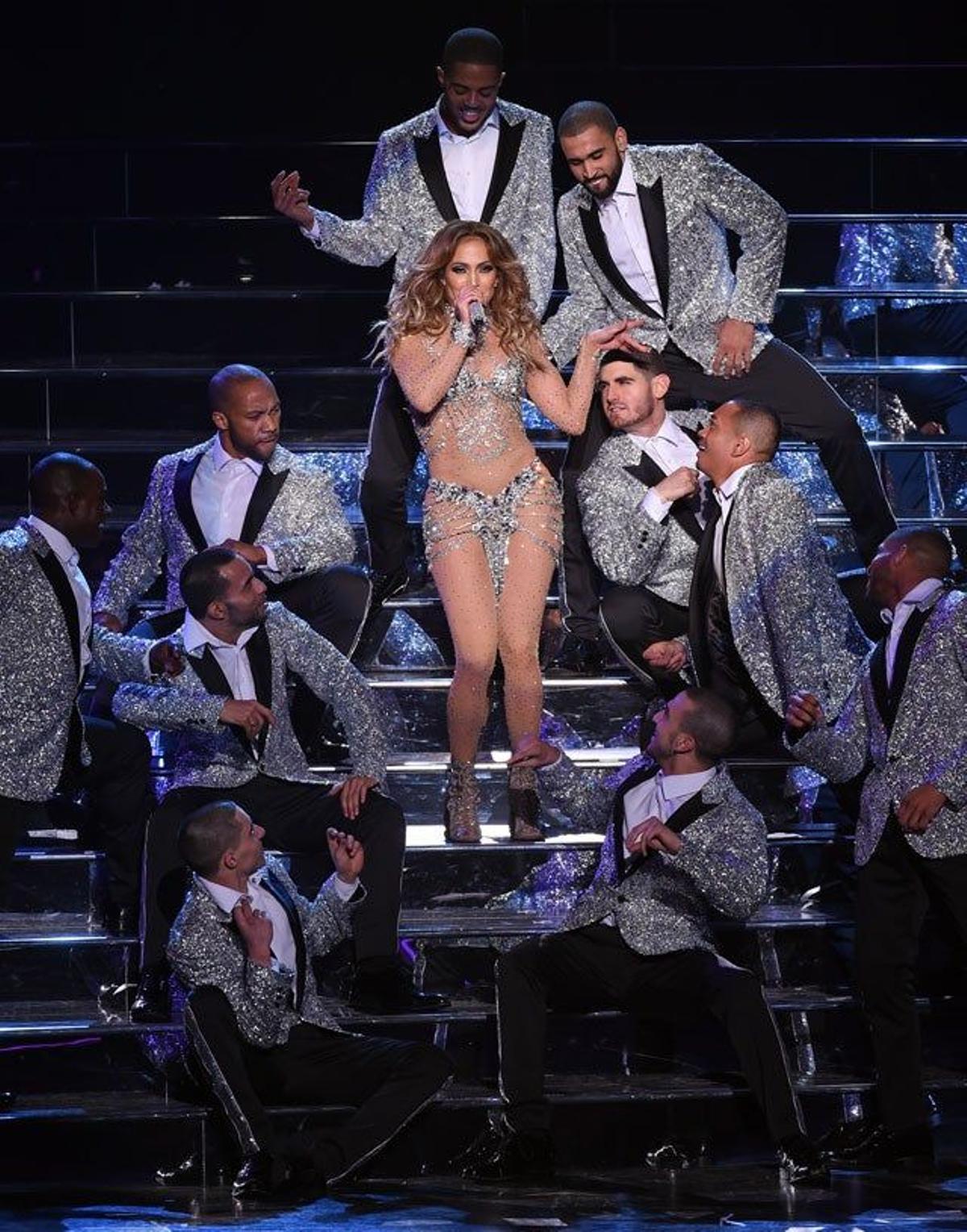 Jennifer Lopez baja las escaleras con los bailarines alrededor
