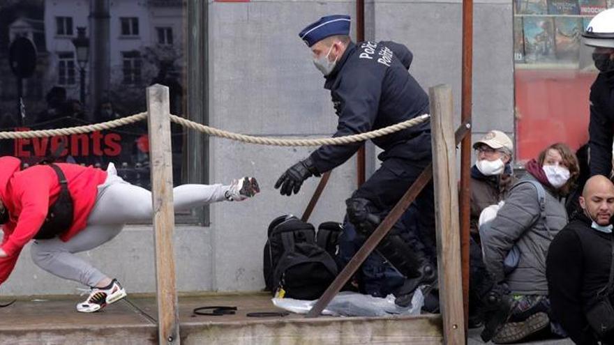 Un agente detiene a uno de los manifestantes frente a la Estación Central.