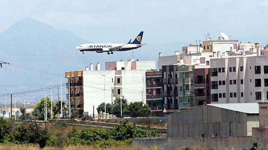 Una aeronave se dispone a aterrizar con edificaciones de El Altet en primer plano.