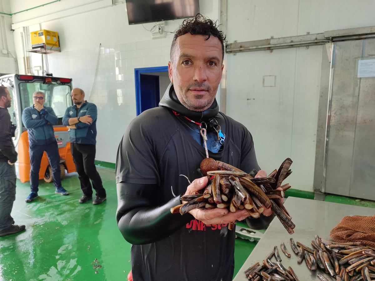 Javier Tenorio descargando ayer navaja en la lonja de Aldán.