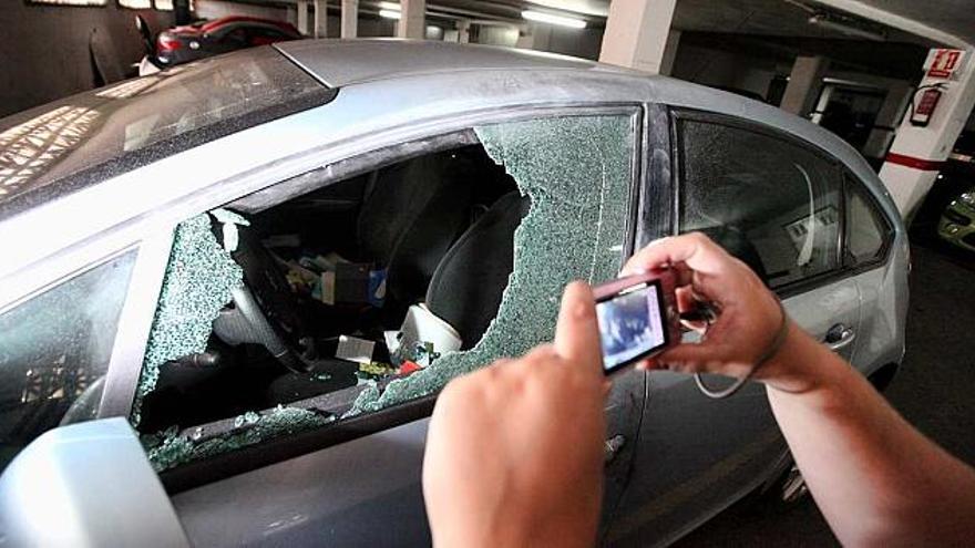 Un propietario toma una foto a uno de los vehículos asaltados en un garaje de Finestrat.