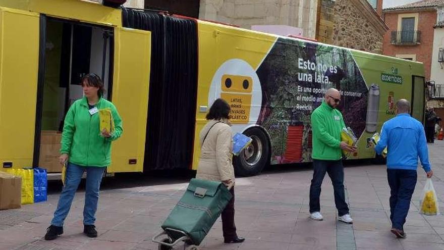 Dos colaboradores de Ecoembes repartiendo las bolsas.