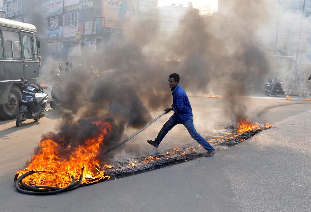A demonstrator drags burning tyres during a ...