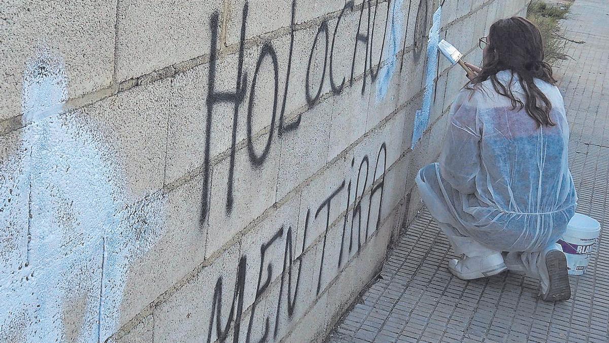 Voluntarios tapan las pintadas neonazis en Carcaixent