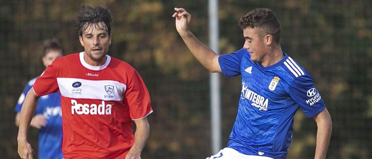 Álex Suárez trata de hacerse con el balón ante Míchel, en el partido que enfrentó al Vetusta y al Marino. |