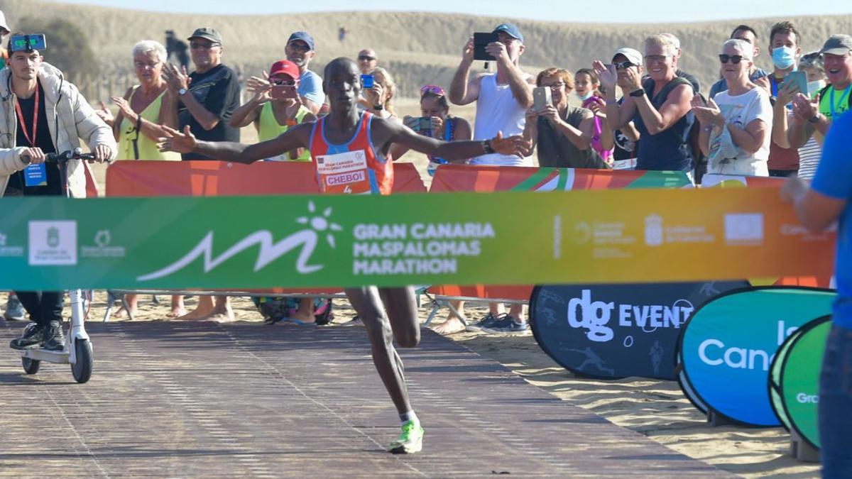 El atleta keniata William Ruto Cheboi, justo en el momento anterior de traspasar la línea de meta de la Gran Canaria Maspalomas Marathon como ganador, ayer, sobre la arena de las Dunas. | | JUAN CASTRO