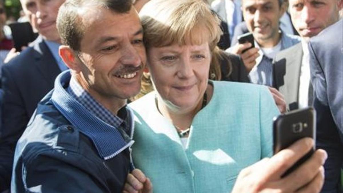 La cancillera se hace un selfi con un refugiado durante su visita de ayer a la visita de Migración de Berlín.