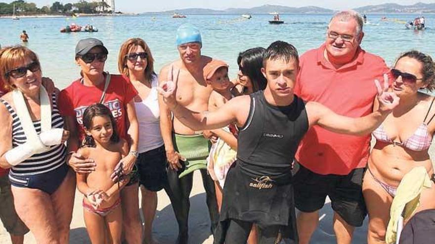 Marcos Rodríguez hace el gesto de la victoria, ayer, a su llegada a la playa de O Vao, rodeado de familiares y amigos.  // Jesús de Arcos