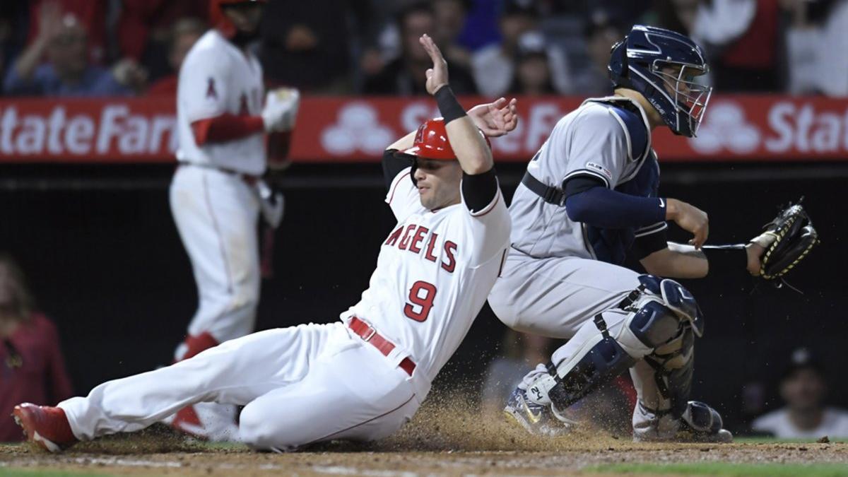 Tommy La Stella # 9 de Los Angeles Angels of Anaheim pasa a Gary Sanchez # 24 de los New York Yankees para anotar en la sexta entrada en el Angel Stadium de Anaheim en Anaheim, California.