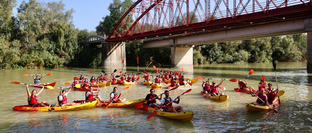 Piragüistas en el río Guadalquivir a su paso por Villafranca de Córdoba, con el puente de hierro al fondo.