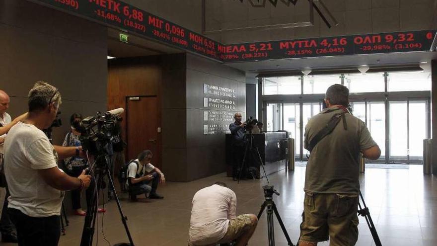 Periodistas toman imágenes, ayer, en la Bolsa de Atenas.