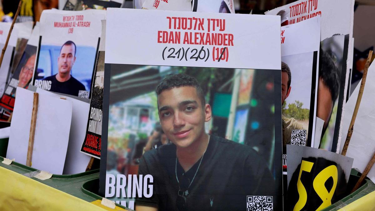 Un cartel con el rostro del rehén israelí-estadounidense Edan Alexander (C), retenido por Hamás en Gaza desde octubre de 2023, aparece entre retratos de otros israelíes cautivos en territorio palestino en la Plaza de los Rehenes de Tel Aviv el 12 de mayo de 2025.