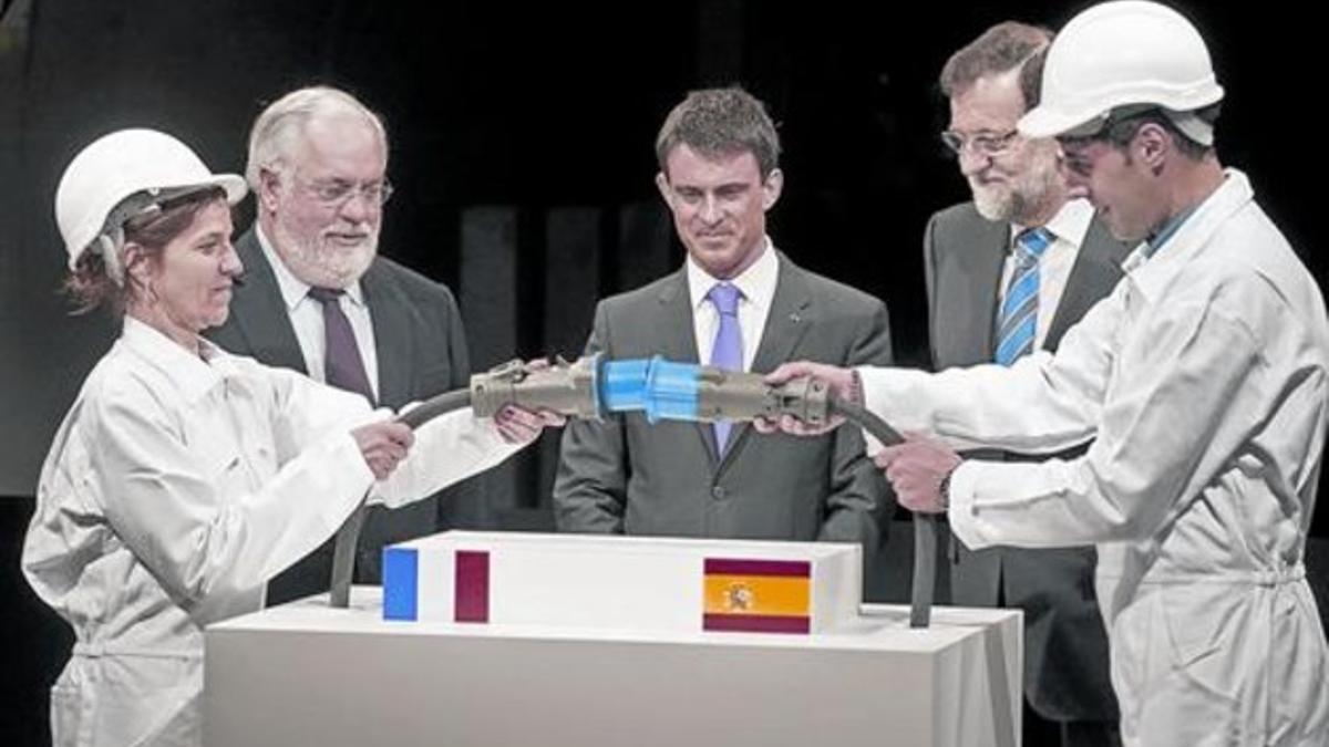 Arias Cañete, Valls y  Rajoy observan la conexión de la línea eléctrica que enlaza España y Francia.