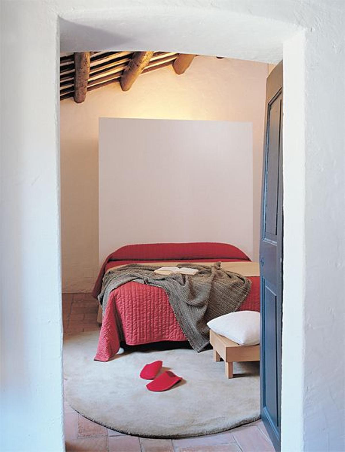 CABECERO DE OBRA. En el dormitorio principal, la cama descansa en un cabecero de obra pintado de bla