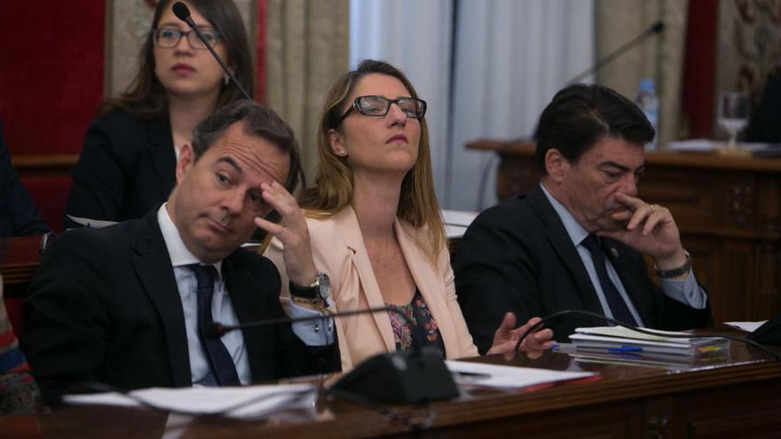 Mari Carmen de España, entre dos compañeros del grupo popular en un Pleno