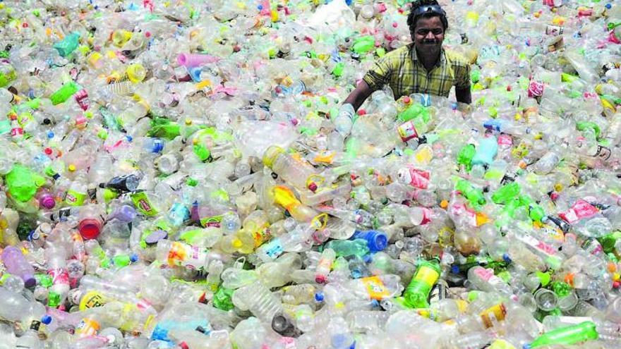 Un home, envoltat d’un mar
d’ampolles de plàstic, 
a l’Índia. |  SHAMMI MEHRA