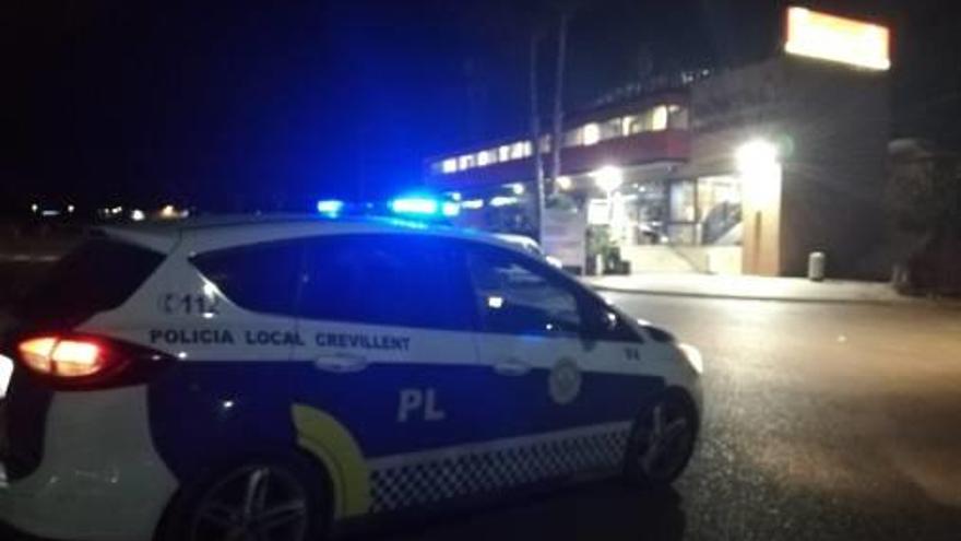 Un coche policial en el área de servicio tras el asalto nocturno.