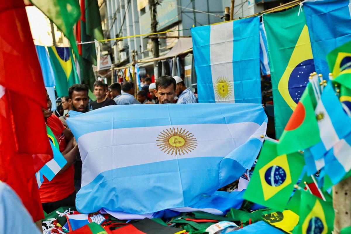 Fans gather at a street shop to purchase flags of their desired team ahead of FIFA world cup, in Dhaka