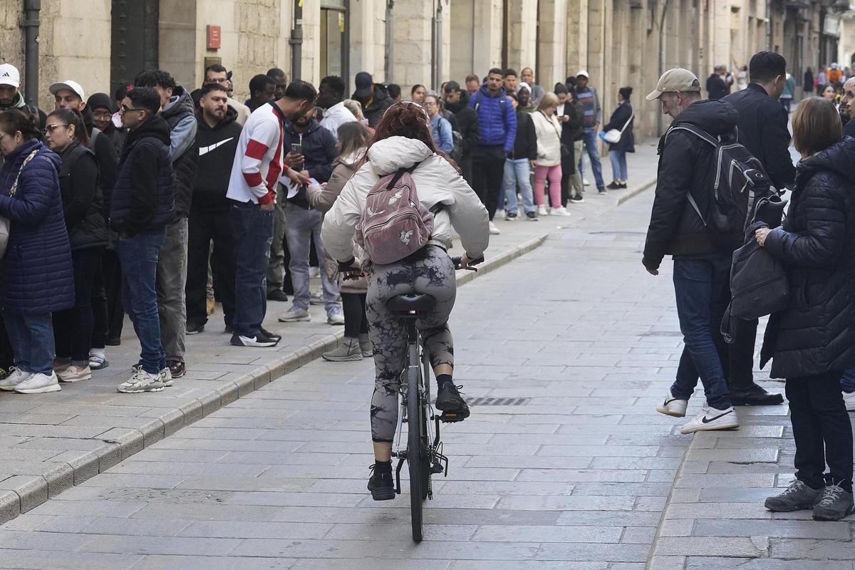 Una noia pedala en bicicleta pel Barri Vell de Girona.