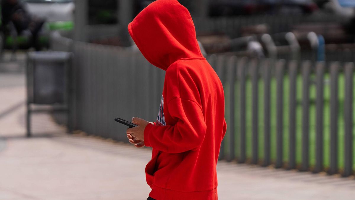 Un adolescente consulta su teléfono móvil.