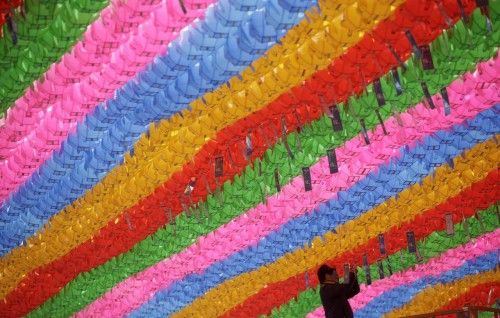 A worker attaches prayer petitions to lotus lanterns in preparation for the upcoming birthday of Buddha at Jogye temple in Seoul