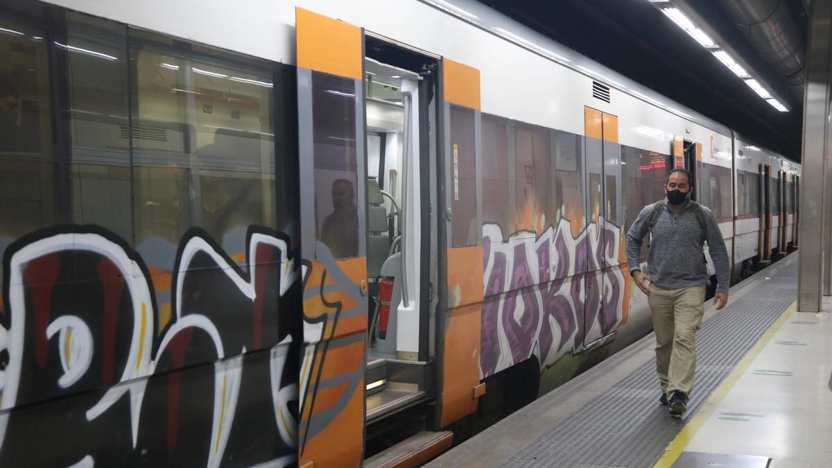 Un passatger de Renfe sortint d&#039;un tren de la companyia a l&#039;andana de l&#039;estació de Sants de Barcelona.