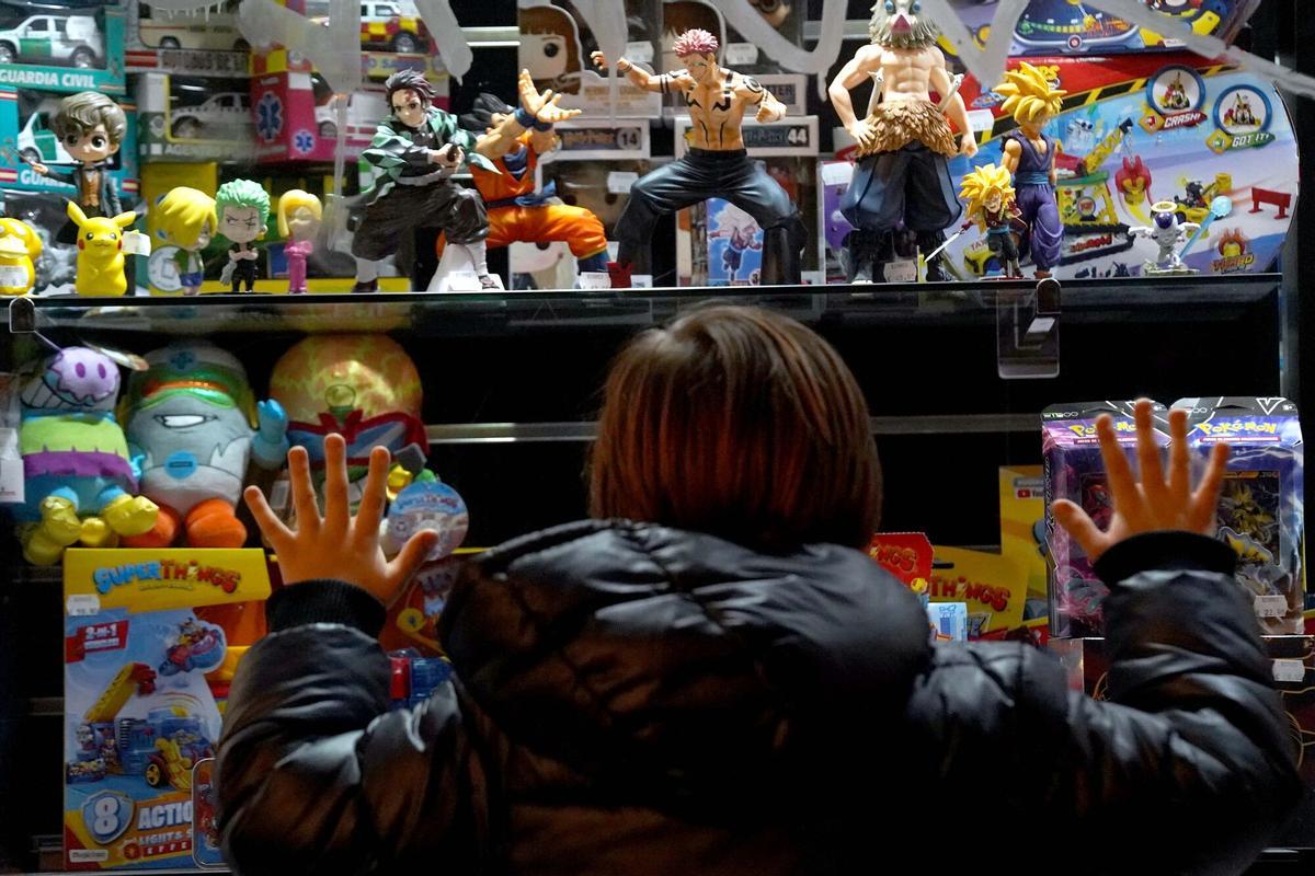 Un niño de ocho años observa un escaparate lleno de regalos