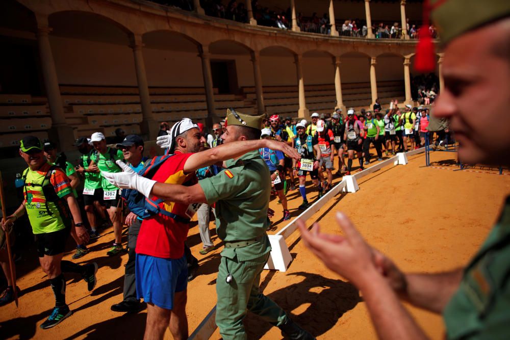 A runner is embraced by a Spanish legionnaire ...