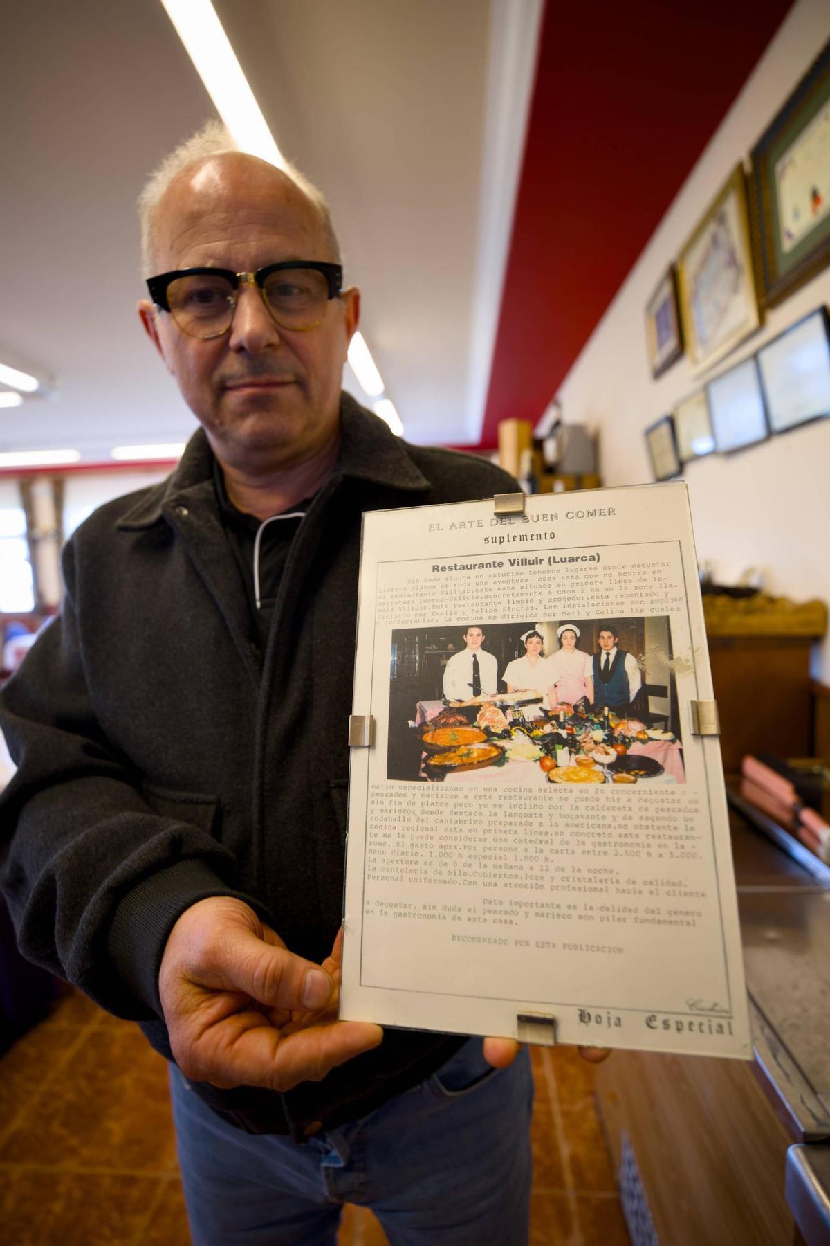 Evelio Sánchez sostinene una foto de los inicios del restaurante, en la que aparecen los hermanos Evelio y Felipe Sánchez, Luisa Fernández y Celina García.