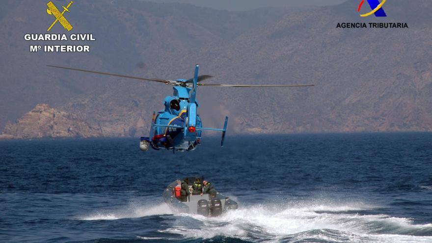 Un helicóptero de Aduanas junto a una lancha de la Guardia Civil