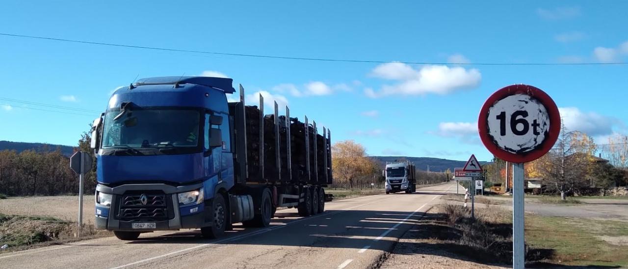 Camiones cargados de madera pasan por la carretera de Ferreras de Abajo