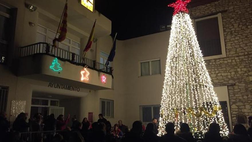 Los niños encienden la Navidad con sus adornos en el árbol