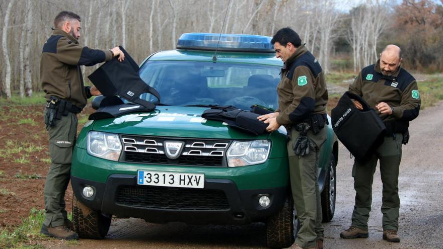 Tres Agents Rurals fent un control de caça. Al costat del vehicle, s&#039;equipen amb armilles antibales, foto d&#039;arxiu