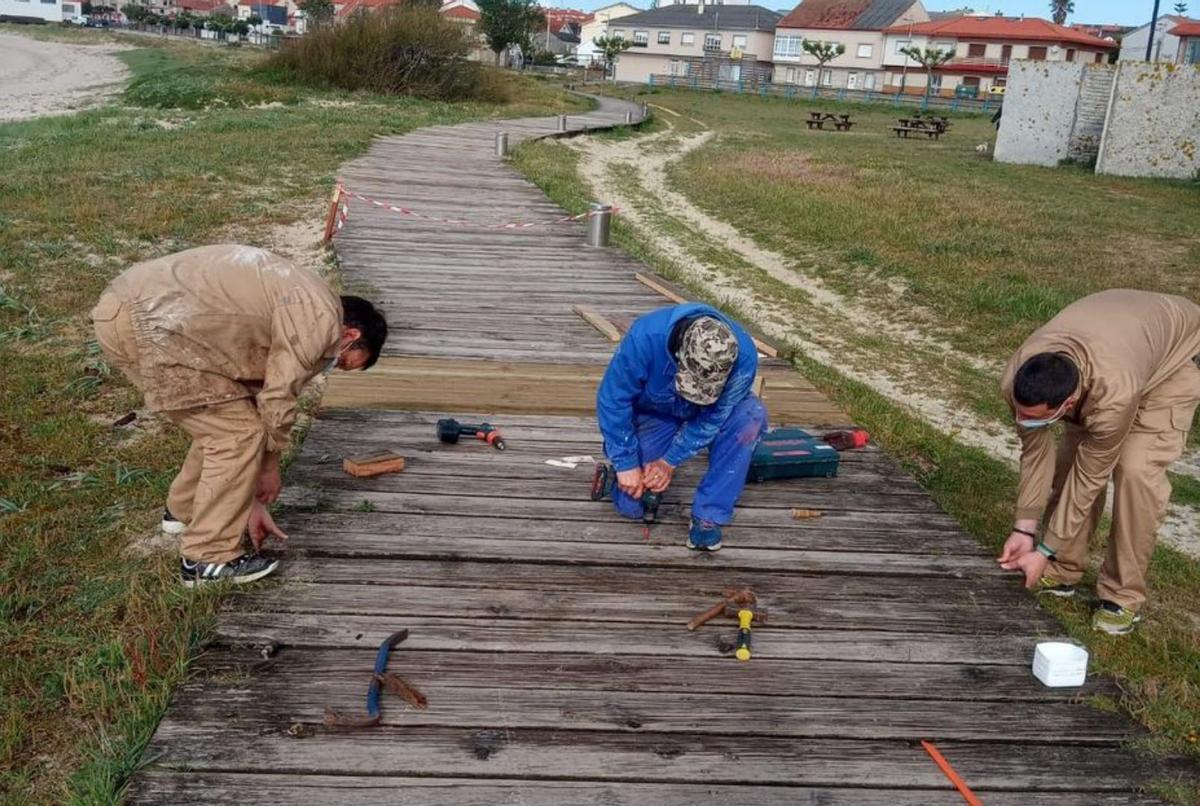 Alumnos del taller de carpintería de la UAD instalando una pasarela / c.r.