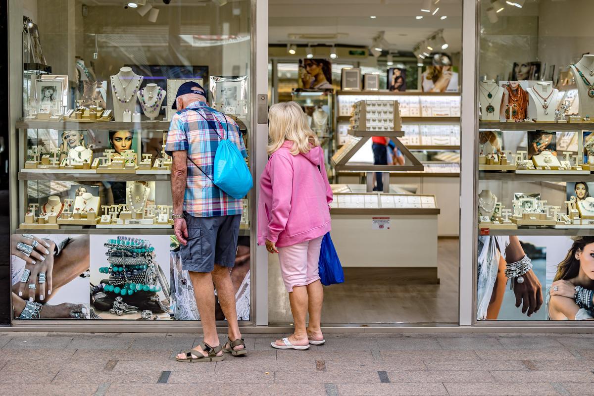 Dos personas observan el escaparate de una tienda de Benidorm.