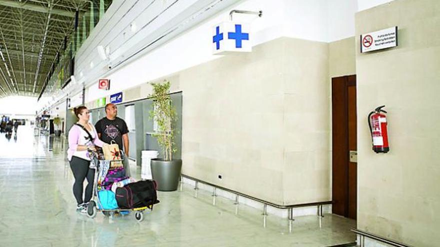 Una pareja observa las dependencias médicas cerradas en el aeropuerto de Fuerteventura, ayer. | gabriel fuselli