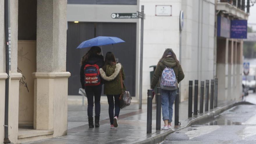 Peatones con paraguas esta mañana en Elche