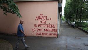 Un vecino de Nanterre pasa frente a un grafiti que reza Nahel es el hermano pequeño de todo Nanterre, sin justicia no hay paz, este sábado.