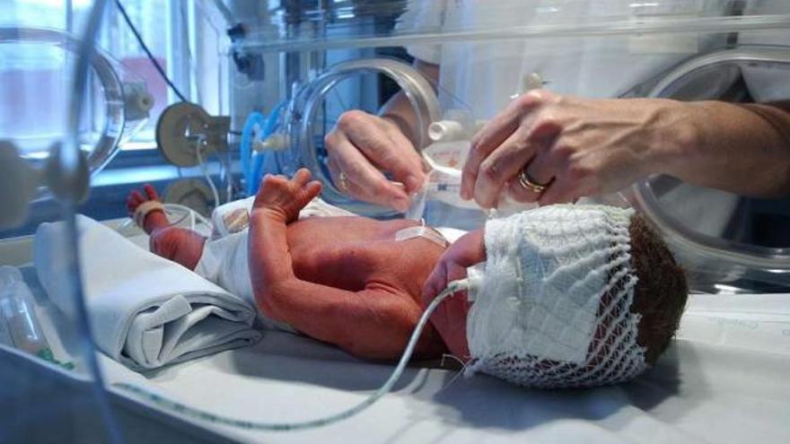 Una enfermera atiende a un niño prematuro en el hospital. / grobas