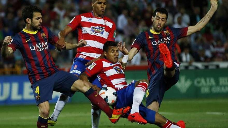 Cesc y Busquets pelean por un balón junto a los granadinos El Arabi y Bravo. // Efe