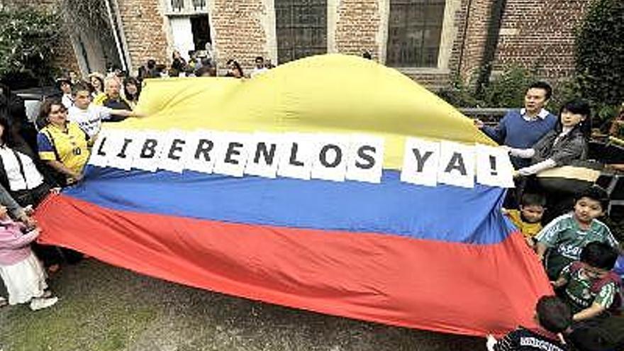 Varios de los participantes muestran una bandera colombiana con el lema ´Liberenlos ya!´, en el acto organizado hoy en Bruselas por el Comité Ingrid Betancourt para pedir el cese de la violencia y liberación de rehenes por parte de las FARC.