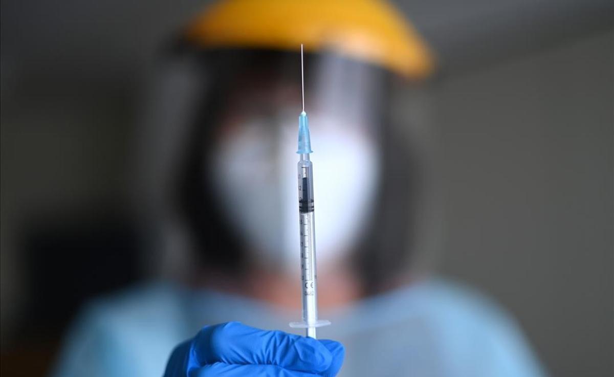 Una inyección con la vacuna del covid de Pfizer-BioNTech, sostenida por un miembro del personal sanitario en la residencia para mayoers Schmallenbach Haus, en Froendenberg (Alemania).