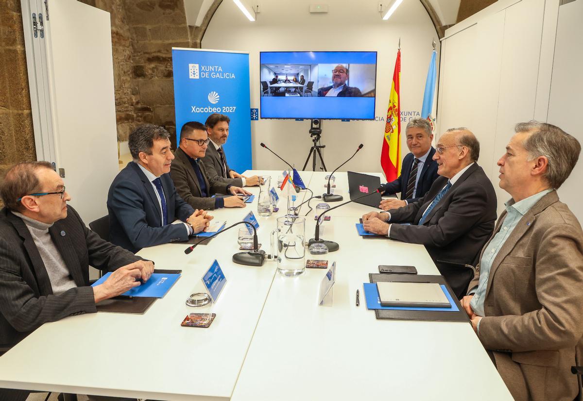 Los tres rectores gallegos, con los responsables de Emigración y Universidades de la Xunta, y, en la pantalla, con el de Universidades del Gobierno central