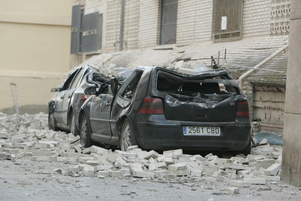 Un par de coches aplastados por los escombros en 2011 tras el terremoto de Lorca.