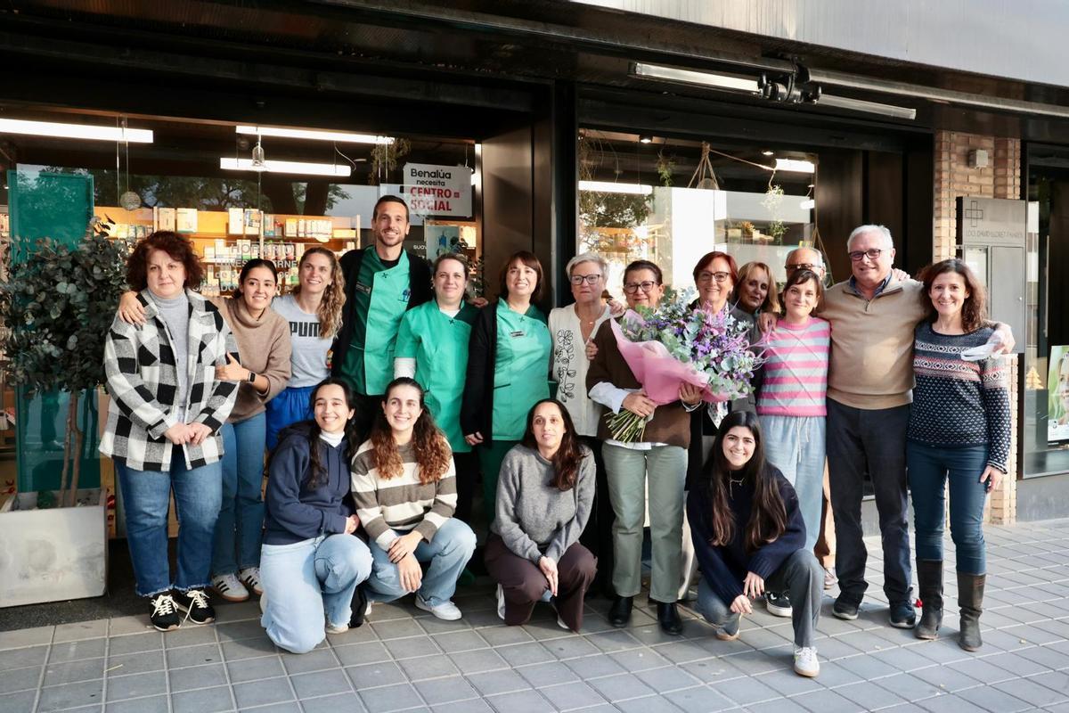 La familia de boticarios y el resto del personal farmacéutico y de laboratorio posan con la homenajeada