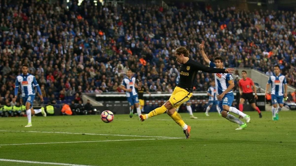 Griezmann remata a puerta para marcar el gol que tumbó al Espanyol mientras Javi López pide fuera de juego, anoche en Cornellà.