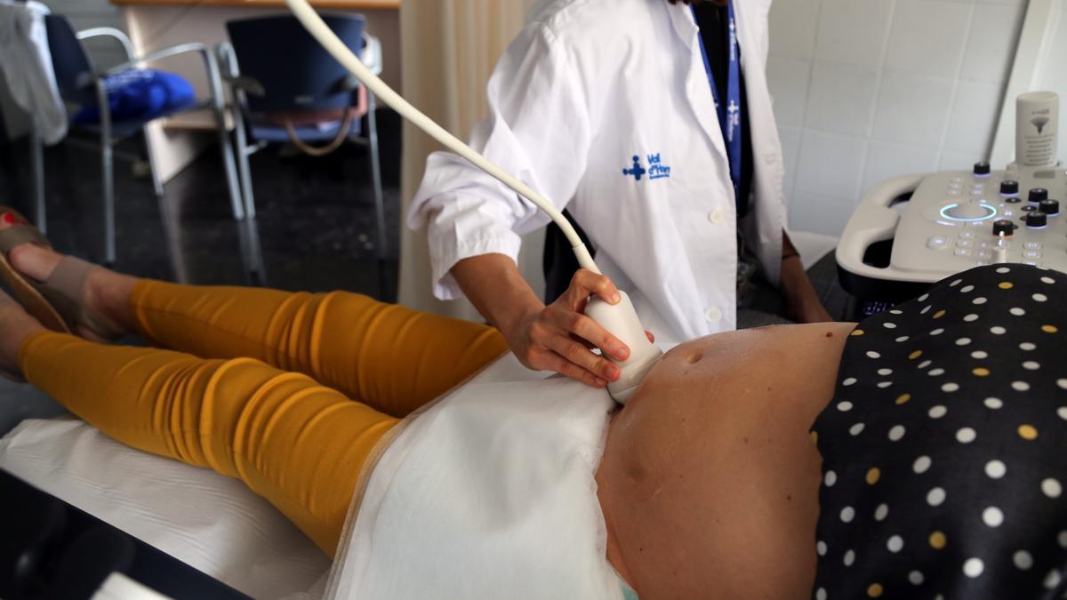 Una doctora fa una ecografia a una dona embarassada durant un assaig clínic a la Vall d’Hebron